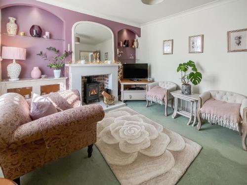 a living room with a couch and a fireplace at Lavender Cottage in Louth