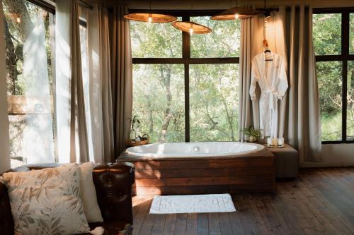 a bath tub in a room with a large window at Maroelani Lodge- Greater Kruger Private Reserve in Hoedspruit