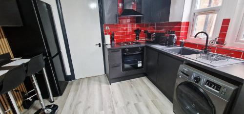 a kitchen with a washing machine and red tiles at Modern Flat Close to Oxford City Centre in Oxford