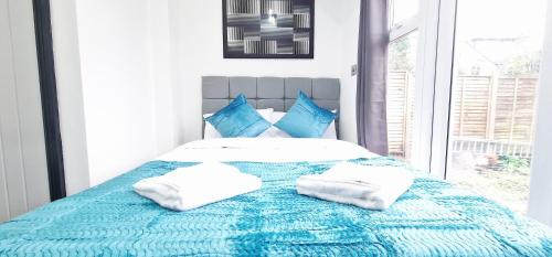 a blue and white bed with two pillows on it at Modern Flat Close to Oxford City Centre in Oxford