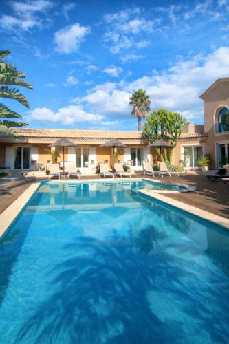 a swimming pool in front of a house at Casa Canavial in Luz