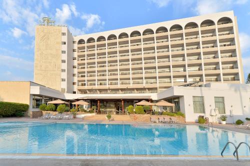 a hotel with a large swimming pool in front of a building at Ajax Hotel in Limassol