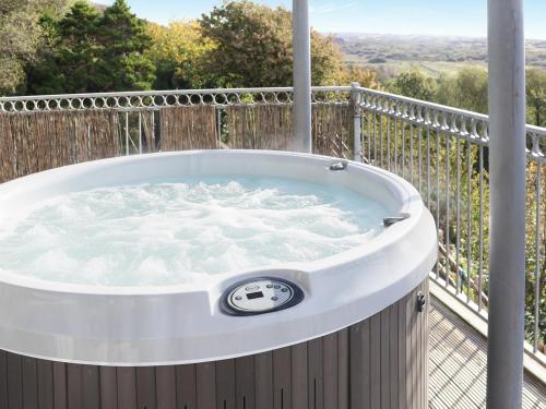 a jacuzzi tub on the deck of a house at The Lookout in Pendine
