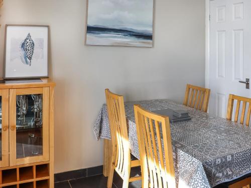 a dining room with a table and chairs at The Lookout in Pendine
