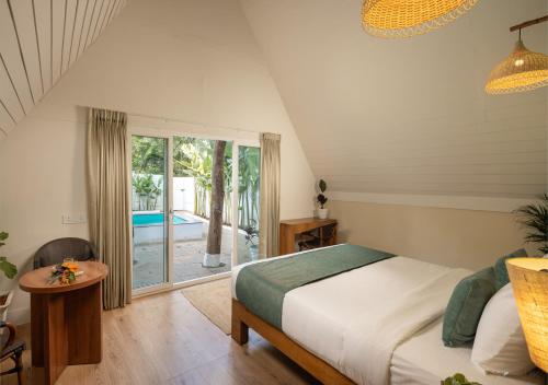a bedroom with a bed and a view of a pool at Jalvasa Villa's in Canacona