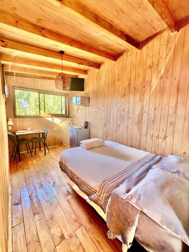 a bedroom with a bed in a wooden room at Tiny House Pangal in Pichilemu