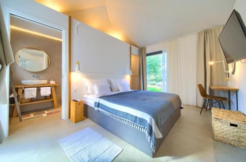 a bedroom with a large bed and a mirror at Margari Villas in Linardići