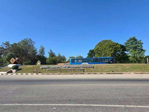 a bus is parked on the side of a road at Toon Guesthouse Sukhothai in Sukhothai
