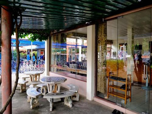 a table and chairs in front of a store window at Toon Guesthouse Sukhothai in Sukhothai