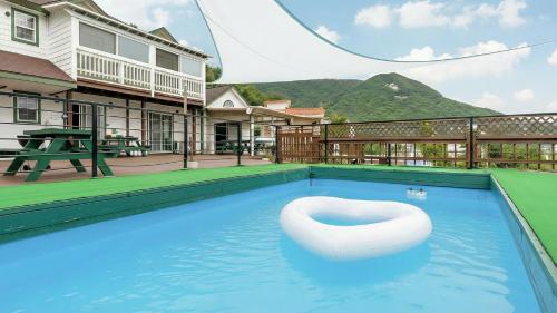 a swimming pool with a white chair in the water at Ganghwa Daeun pension in Incheon