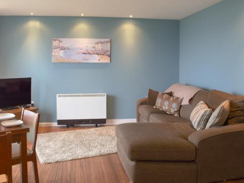 a living room with a couch and a flat screen tv at Gower Sunset Views in Llanelli
