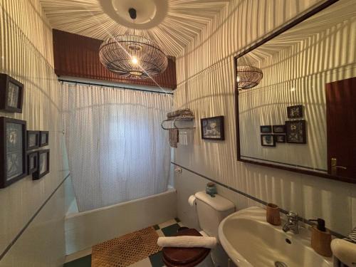 a bathroom with a sink and a toilet and a mirror at Suite Bela Vigia 4 in Jardim do Mar