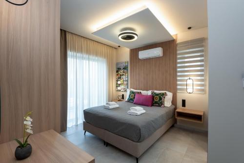 a bedroom with a bed and a large window at Golden Silence in Platanias