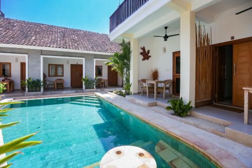 a villa with a swimming pool and a house at Green Banana in Gili Trawangan