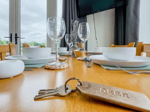 a table with a pair of keys on a wooden table at Deer Lodge - Ukc4325 in Pidley