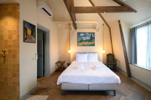 a bedroom with a white bed in a room at Boetiekhotel Het Gezellenhuis in Ouderkerk aan de Amstel
