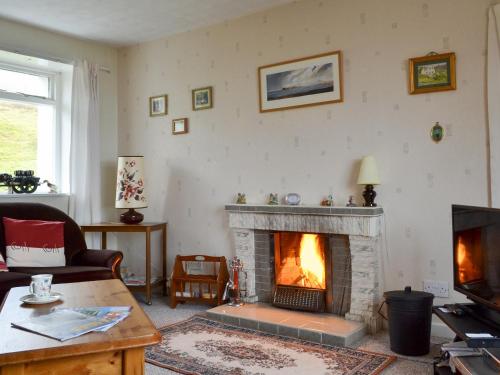 a living room with a fireplace and a couch at Tigh Mairi in Tarbert