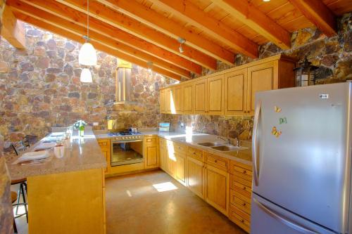 a kitchen with wooden cabinets and a white refrigerator at Rancho El Rossinyol in Valle de Guadalupe