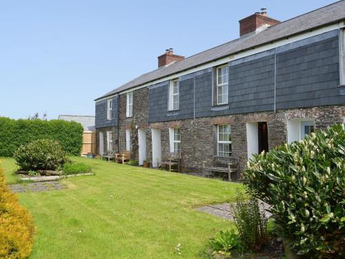 an old brick building with a yard in front of it at 7 Quarrymans Cottage in Wadebridge