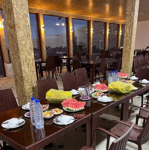 a table with plates of food and water bottles at Aydarkul Beach in Taldy