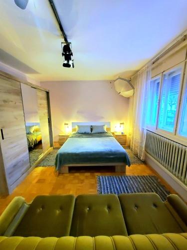 a bedroom with a bed and a couch at Apartment PER DAY in Vrbas
