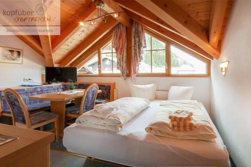 a bedroom with a bed in a room with a table at Edelweißhof in Ischgl