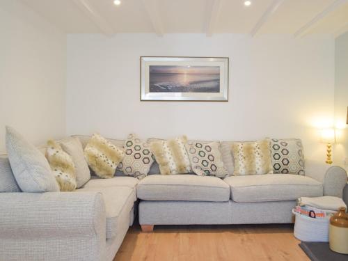 a living room with a couch with pillows on it at Snowdrop Cottage in Fishguard