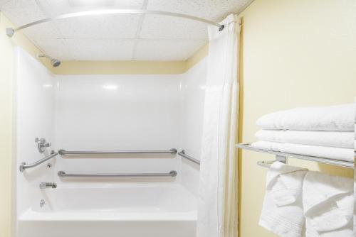 ein Badezimmer mit weißen Handtüchern und einem Handtuchhalter in der Unterkunft Super 8 by Wyndham Jacksonville in Jacksonville