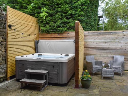 a hot tub with two chairs and a table at Ye Olde Mottram Chip Shop in Glossop