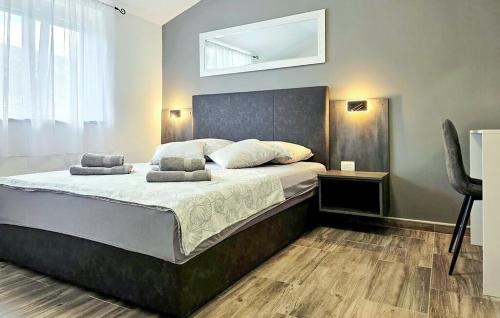 a bedroom with a large bed with two pillows on it at Villa Lux with swimming pool in Baška