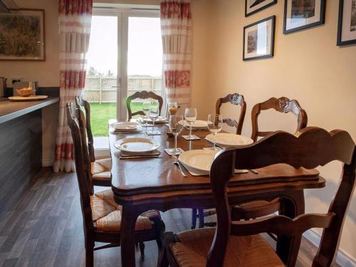 a dining room with a wooden table and chairs at Grant Crescent in Dornoch