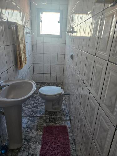 a bathroom with a toilet and a sink at Kitnet Estrela do Mar in Peruíbe