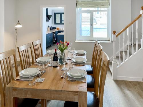 a dining room table with plates and wine glasses at April House in Amble