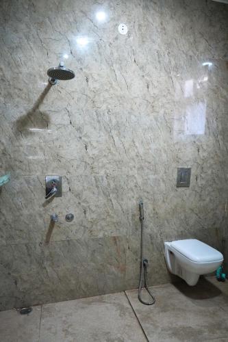 a bathroom with a shower and a toilet in a wall at Echoes of Doon in Rājpur