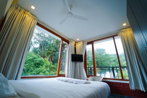 a bedroom with a bed and a large window at Palm Cove Resort And Spa in Jāmb