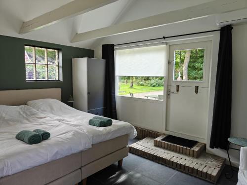 a bedroom with a large bed and a window at Theehus in Steggerda