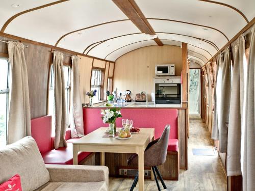 a dining room and kitchen in a train car with a table at Brunel Boutique Railway Carriage 3 in Dawlish Warren