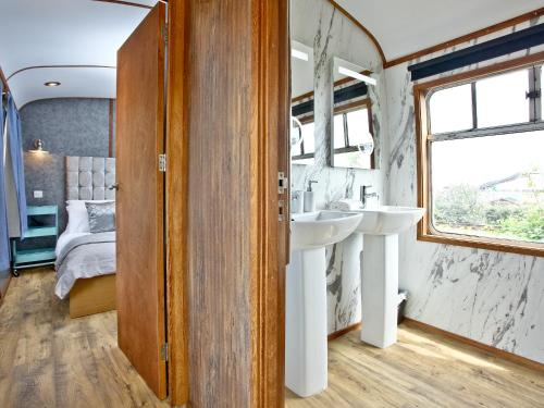a bathroom with a sink and a bedroom at Brunel Boutique Railway Carriage 3 in Dawlish Warren