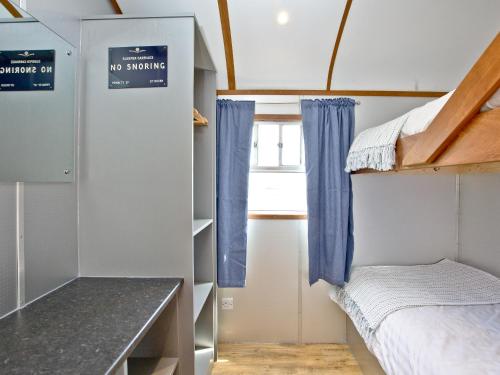 a small room with a bunk bed and a window at Brunel Boutique Railway Carriage 3 in Dawlish Warren