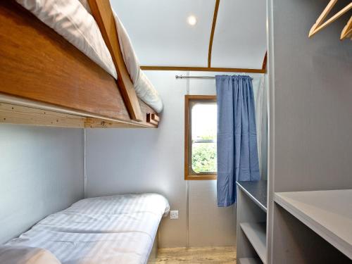 a small room with a bed and a window at Brunel Boutique Railway Carriage 3 in Dawlish Warren
