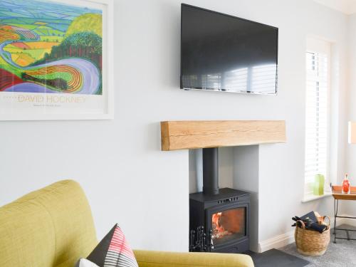 a living room with a fireplace with a flat screen tv at Poppys' Place in Sewerby