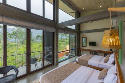 a bedroom with two beds and a balcony at Sathkara Resort Ella in Ella