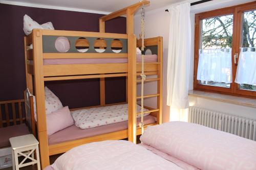 a bedroom with two bunk beds and a window at Bergflügel Fewo Allgäu, Schwimmbad, Sauna, Skilift in Missen-Wilhams