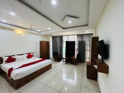 a bedroom with a bed and a television in it at Homey - vythiri bus station in Vythiri