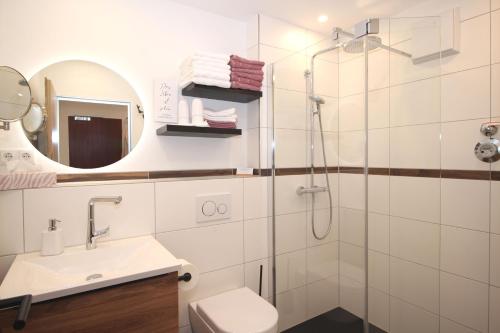 a bathroom with a shower and a toilet and a sink at Bergflügel Fewo Allgäu, Schwimmbad, Sauna, Skilift in Missen-Wilhams