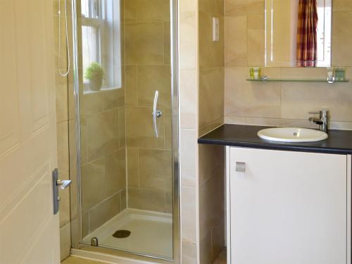a bathroom with a shower and a sink at Holly Lodge in Aviemore