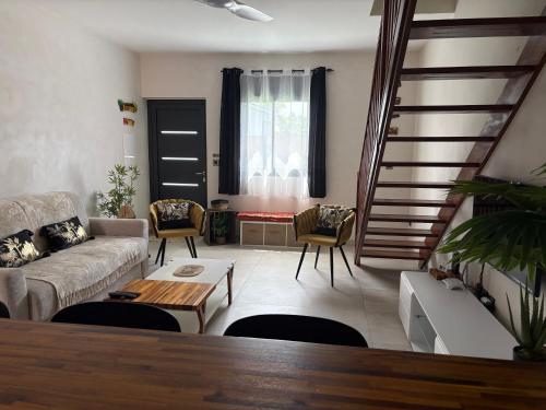 a living room with a couch and a staircase at Ô Ti' Lodge Vanilla in Bras-Panon