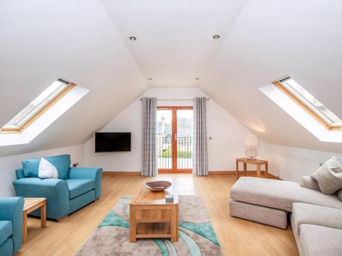 a living room with skylights and blue furniture at The Hive in Dornoch
