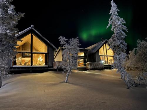 an image of a house with the aurora in the sky at AURA Arctic Chalets - Grand Panoramic & Grand Hideaway in Saariselka