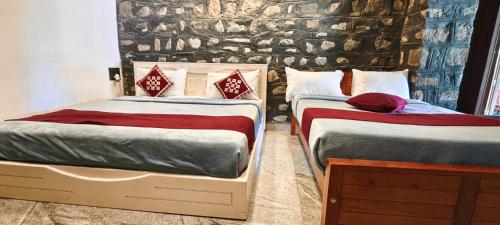two beds sitting next to each other in a bedroom at Elephant County Resort in Masinagudi